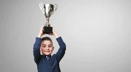 A kid holding a trophy.