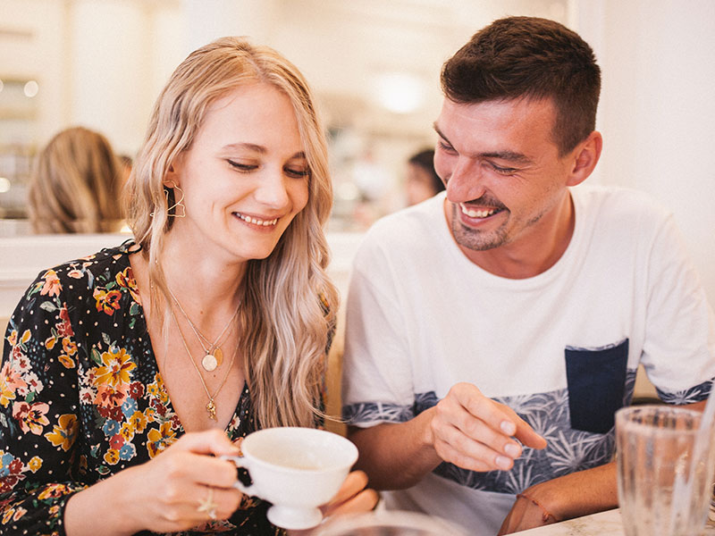 A couple sitting in a cafe enjoying a coffee date together